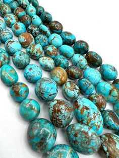 several turquoise and brown beads on a white surface