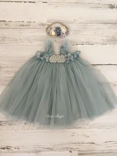 This listing if for a dusty or vintage blue flower tutu dress!  Perfect for that 1st birthday!!  *This dress comes as is (with no "one")- "Dress only" option from the drop down menu Dress with one (just the one dress) One Dress with headband   ~headband elastic can be made in any color! ~ ships within 1 to 3 business days (message me with any additional questions)! ~ headband backed with felt for comfort {{SIZING}}  6-9 months (fits 18-20 lbs.) 9-12 months (fits 20-22 lbs.) 12-18  months  (fits 22-26 lbs.) 18-24 months  (fits 26-30 lbs.)  Don't forget to like my Facebook page for 10% off coupon https://www.facebook.com/IssaBugsBoutique/ Please feel free check out other items in my shop. I love custom orders so please convo me with any special requests! http://www.etsy.com/shop/Issabugsbout Flower Tutu, Headband Elastic, 1st Birthday Dresses, Baby Girls Dresses, Boho Baby Girl, Baby 1st Birthday, Blue Tulle