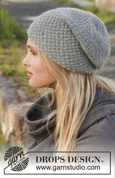 a woman with long hair wearing a gray knitted beanie hat and looking off to the side