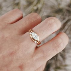 a person's hand with a gold ring on it and a white diamond in the middle