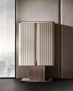 a tall white cabinet sitting on top of a hard wood floor next to a window