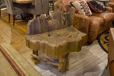 a wooden bench sitting in the middle of a living room next to a table and chairs