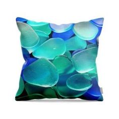 a blue and green pillow with sea glass on it