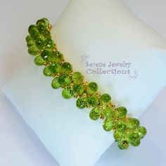 Italian made Green Peridot bead 18k yellow gold bracelet! Many 18k gold balls are scattered throughout the bracelet in between the peridot beads. A small white gold clasp completes the bracelet. There is one small 3 pointer diamond on the clasp. Total Weight: 54 grams Bracelet length: 7 inches Precious Metal: 18k yellow gold Precious stones: -Peridot Teardrops 9mmx5.2mm -White Round Diamonds: 0.03 carat, QTY 1 (on the clasp) Hallmark: 750 Elegant Green Bracelet With Faceted Beads, Elegant Green Faceted Bead Bracelet, Elegant Green Bracelets With Faceted Beads, Faceted Yellow Gold Beaded Bracelets, Yellow Gold Faceted Beaded Bracelets, Elegant Lime Green Faceted Jewelry, Yellow Gold Rondelle Gemstone Beaded Bracelets, Green Faceted Bead Bangle Jewelry, Elegant Peridot Round Beads Jewelry