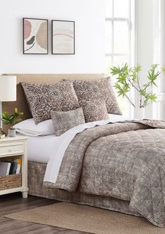 a bed in a room with white walls and wooden flooring next to a window