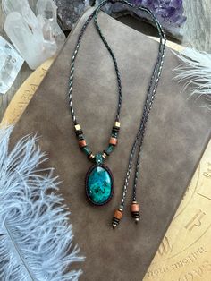 a long necklace with a turquoise stone pendant