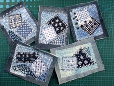 four quilted coasters are sitting on a cutting board with green and blue background