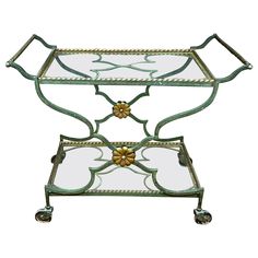 a metal and glass serving cart with wheels