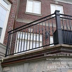 an iron railing on the side of a brick building