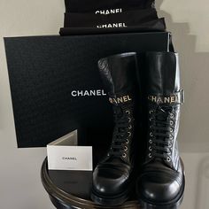 This Is An Authentic Pair Of Chanel Shiny Calfskin Lace Up Combat Boots Size 38.5 In Black. These Stunning Boots Are Crafted Of Calfskin Leather In Black. The Boots Feature A 1.5-Inch Heel And A Grosgrain Fabric Cap Toe With A Gold Chanel Logo. Wore A Handful Of Times And In Great Condition. Have Original Box,Dust Bag And Chanel Card. Luxury Black Calf Leather Combat Boots, Luxury Calf Leather Combat Boots With Lace-up, Combat Boot Chanel, Gold Chanel Logo, Luxury Calf Leather Combat Boots With Lace-up Fastening, Chanel Boots Farfetch, Lace Up Combat Boots, 5 Inch Heels, Moto Boots