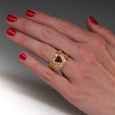 This impressive ring is centered with one (1) triangular mixed cut natural pink tourmaline set into bezel style setting. The ring is also accented with two- rows of ten (10), bead set, round brilliant cut diamonds. The ring measures 14.3mm at the top, rises 6.8mm above the finger, tapering to 6.8mm wide and 2.4mm thick at the base of the shank. This ring is a size 9 and has limited resizing. There is some gentle abrasion on the tourmaline. Formal Ruby Ring With Tourmaline Accents, Luxury Tourmaline Jewelry For Formal Occasions, Luxury Tourmaline Wedding Jewelry, Fine Jewelry Multi-stone Trillion Cut Ring, Formal Trillion Cut Multi-stone Jewelry, Formal Yellow Gold Tourmaline Jewelry, Luxury Tourmaline Gemstone Jewelry, Luxury Trillion Cut Jewelry With Tension Setting, Formal Multi-stone Ruby Ring With Tourmaline