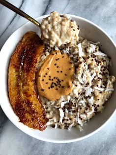 a bowl filled with bananas and rice covered in peanut butter