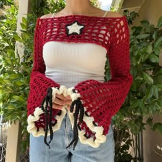 a woman wearing a red and white crocheted sweater with black stars on it