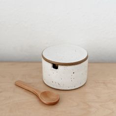 a wooden spoon sitting next to a white container