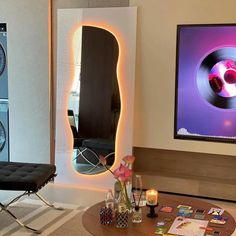 a living room with a large mirror on the wall next to a table and chair