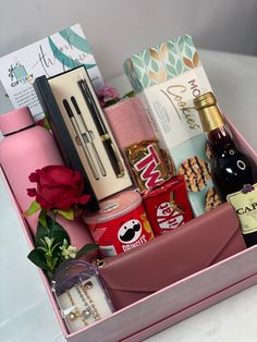 a pink box filled with lots of different types of items next to a red rose