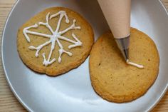 a cookie being decorated with icing on a plate