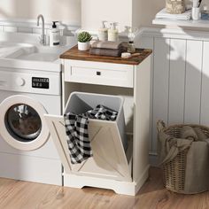 a washer and dryer in a room with white walls, wood flooring and cabinets