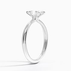 a white gold ring with a princess cut diamond in the center, on a white background