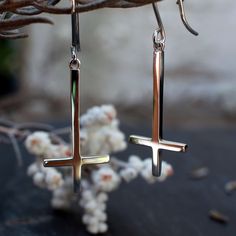 These gorgeous minimalist upside down cross dangle earrings are crafted from solid sterling silver on a hand made shepherd hook. Long enough to be a stunning statement earring at a black metal show and small enough to be comfortable and lightweight to wear. They have a beautiful high polish finish, making them feel quality and luxurious.  Choose a single earring or a pair.  Solid Sterling  Silver 3cm long 1.5cm wide Each earring/pair comes thoughtfully packaged in our Burning Rose Jewellery Co.