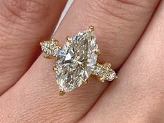 a woman's hand with a yellow gold ring and diamond set in the middle