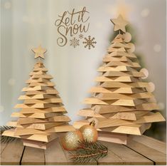 two wooden christmas trees sitting on top of a table