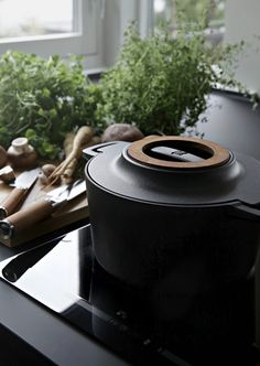 a pot on top of a stove next to some vegetables