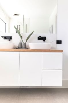 a bathroom with two sinks and a large mirror