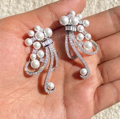 Pearl diamond Earrings featuring semi precious white pearl and cz diamonds. Ideal to pair with your india western sarees and formal outfits. These earrings chendelier design will elevate your look. Perfect gift for her and gift for sister. *𝐏𝐑𝐎𝐃𝐔𝐂𝐓 𝐃𝐄𝐓𝐀𝐈𝐋* * 𝐌𝐚𝐭𝐞𝐫𝐢𝐚𝐥: Brass * 𝐏𝐥𝐚𝐭𝐢𝐧𝐠: White Rhodium Plated * 𝐒𝐭𝐨𝐧𝐞: AAA-quality CZ Diamond. 𝐕𝐢𝐬𝐢𝐭 𝐎𝐮𝐫 𝐅𝐀𝐐𝐬 𝐟𝐨𝐫 𝐒𝐡𝐢𝐩𝐩𝐢𝐧𝐠 𝐏𝐨𝐥𝐢𝐜𝐢𝐞𝐬 𝐚𝐧𝐝 𝐂𝐚𝐫𝐞 𝐈𝐧𝐬𝐭𝐫𝐮𝐜𝐭𝐢𝐨𝐧 *𝐃𝐈𝐒𝐂𝐋𝐀𝐈𝐌𝐄? Luxury Silver American Diamond Chandelier Earrings, Luxury Silver Pearl Chandelier Earrings, Western Sarees, Chandelier Long, Earrings Luxury, Pearl And Diamond Earrings, Designer Replica, Formal Outfits, India Jewelry