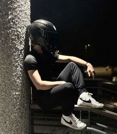 a man sitting on top of a bench wearing a helmet