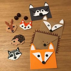 some paper animals that are on a wooden table and one is cut out to look like foxes