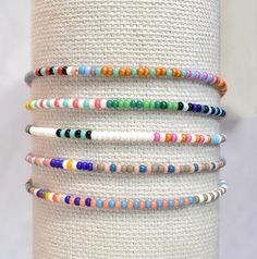 Introducing a beautiful set of random seed bead bracelets, meticulously handmade with love. Inspired by the 'bestseller' summer seed bead bracelets, these bracelets feature tiny beads measuring just 2mm. Perfect for any occasion, these delicate bracelets make a wonderful gift. Embrace the joy of layering bracelets without the heavy or bulky feeling - you'll hardly even notice you're wearing them! The average woman's wrist size is around 7 in When orders are prepared I choose completely random bracelets for each set. If you would like a certain pattern or particular colors please leave a note! :) These are made with high quality elastic bead cord for a flexible but strong fit. By default, your order will either be enclosed in a jewelry bag or on a logo card with a clear resealable envelope 2mm Beads, Layering Bracelets, Cotton Jewelry, Stacking Bracelets, Tiny Beads, Fundraising Ideas, Jewellery Ideas, Jewelry Bag, Bead Bracelets