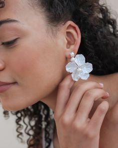 a close up of a person wearing some kind of earring with flowers on it