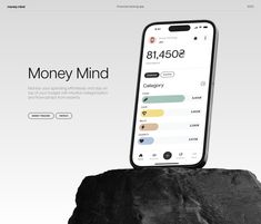 an iphone sitting on top of a rock next to the words money mind above it