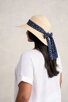 This summer accessory is fashion made easy, bringing a Parisian touch to a classic sunhat design with a polka dotted ribbon in navy and white. Perfect for your next outdoor event or beachside holiday, this sunhat with a subtle gold metallic weave, is crafted from polypropylene braid and straw in a neutral shade that will easily pair with your everyday looks. Navy Hat For Spring, Navy Beach Hat, Chic Summer Straw Hat Packable, Chic Packable Straw Hat For Summer, Navy Brimmed Beach Hats, Navy Brimmed Hats For Beach, Navy Wide Brim Hat For Beach, Navy Beach Hats For Spring, Navy Beach Hat For Spring