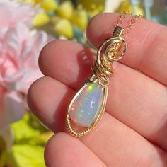 This gorgeous Ethiopian Opal pendant is hand wrapped using elegant 14k yellow gold fill wire. It is a dark base opal with stunning colors consisting of all the colors of the rainbow with a gorgeous play of color. The opal weighs 4.2 carats before wrapped.  This pendant measures just a hair under 1.5 inches tall from the bottom of pendant to the top of the bail. A 14k gold fill chain is available upon purchase (as seen in photos). Chain is removable and interchangeable.  I did my best to provide Yellow Gold Wire Wrapped Jewelry For Healing, Handmade Teardrop Opal Jewelry, Teardrop Ethiopian Opal Jewelry Gift, Ethiopian Opal Birthstone Jewelry As Gift, Handmade Ethiopian Opal Elegant Jewelry, Hand Wrapped Yellow Gold Jewelry As Gift, Hand Wrapped Yellow Gold Jewelry Gift, Hand-wrapped Yellow Gold Jewelry Gift, Ethiopian Opal Gemstone Jewelry For Gifts