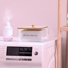 a stack of books sitting on top of a dryer next to a washing machine