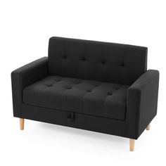 a black couch sitting on top of a white floor