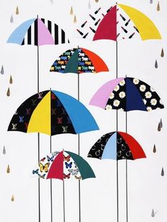 a group of colorful umbrellas hanging from the side of a building with raindrops on them