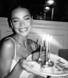 a woman holding a cake with candles on it