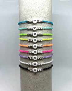 This listing is for one neon seed bead bracelet accented with 3mm sterling silver beads and silver acrylic heart. These can be worn alone or added to a stack to bring a pop of color! Vibrant color choices include: Blue, Aqua, Lime Green, Yellow, Orange, Pink, Purple, White & Black. 5.5 is most common child size 6.5 is most requested size for women.  Please do not hesitate to ask any questions regarding sizing/style.  P.S. I love you was founded to commemorate shop owner's late father. May we always remember to tell the people in our lives that we love them. Seed Bead Bracelet Design Ideas, Seed Bead Bracelets Ideas Color Combos, Seed Bracelet Ideas, Seed Bead Bracelet Ideas, Bracelets Kids, Neon Bracelets, Motivational Bracelets, Wrist Stacks, Bead Crafts Diy