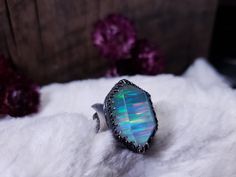 "This listing is for one handmade ring. The aura opal is a synthetic opal made of the same components as natural opal. This aura opal has been topped with quartz. This stone has a soft blue hue with stripes of rainbow flashes. The stone is set in a raised crown-like setting. The band is a doubled patterned band with a crescent moon on ether side. The ring is made with .925 sterling silver. Ring size: 8.75 (will fit a 8.25-8.5) Height x width: 1 x 7/8\" (in inches) The doubled band has a more snu Spiritual Opal Ring For Healing, Handmade Mystical Opal Ring For Gift, Handmade Opal Crystal Ring As Gift, Unique Ethiopian Opal Ring, Handmade Iridescent Opal Ring As Gift, Handmade Iridescent Opal Ring Gift, Handmade Iridescent Opal Ring For Gift, Iridescent Opal Ring As A Gift, Iridescent Opal Ring Gift