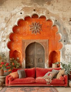 a living room with an orange couch and potted plants in front of the door