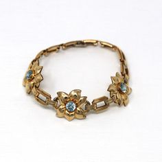 Lovely vintage circa 1940s era 10k gold filled genuine zircon bracelet! This stylish bracelet is comprised of open metal flower panels, that features 3.30 total carats of genuine zircons. The blue gems are securely bezel set, and the bracelet secures with a fold over clasp. A fashionable piece of retro signed jewelry!  ERA - Circa 1940s - Retro METAL / MATERIAL - 10k gold filled, genuine zircons (approx. 3.30 CTW)  MARKINGS / HISTORY - Bracelet is marked "EB 1/20-10k Gold Filled" for Engel Brothers, Inc. The firm was based in NY, NY and went into business around 1930. CONDITION - Good vintage condition. Gold Filled metal has been professionally polished & cleaned. Age appropriate patina & wear remains. Genuine gemstones are secure. Amazing vintage genuine zircon bracelet!  MEASUREMENTS - L Vintage Yellow Gold Bracelet With Jewels, Vintage Yellow Gold Bracelets With Jewels, Vintage Blue Jewelry With Jubilee Bracelet, Vintage Blue Jubilee Bracelet Jewelry, Zircon Bracelet, Flower Panels, Logo Gifts, Stylish Bracelet, Metal Flower