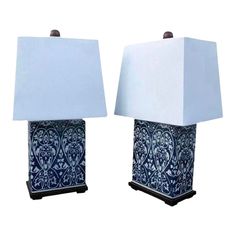 pair of blue and white ceramic lamps with shades on each lamp, one has a square shade