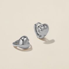 Heart goes padam padam in these hoops. Boo’s chubby heart motif, set on a 6mm huggie, are the sweetest addition to your ear stack. Minimal, sophisticated and chic, these shapely hoops will have hearts skipping beats. Created for you in the finest 14 karat white gold, you'll want to wear these earrings always and never take them off, even when working out or in the shower. Silver Heart Charm Huggie Earrings, Trendy Huggie Hoop Earrings With Heart Charm, Silver Huggie Earrings With Heart Charm, Silver Huggie Heart Charm Earrings, Everyday Heart-shaped Huggie Earrings In Sterling Silver, Everyday Heart-shaped Sterling Silver Huggie Earrings, Trendy Huggie Earrings For Valentine's Day, Trendy Huggie Heart Earrings With Heart Charm, Silver Huggie Heart Earrings For Everyday