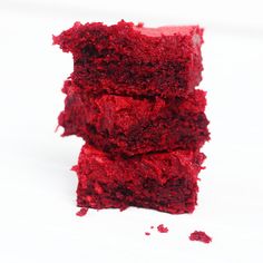 three pieces of red cake sitting on top of each other