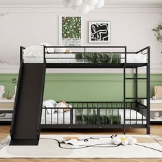 a black bunk bed sitting on top of a wooden floor next to a green wall