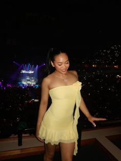 a woman in a yellow dress is smiling at the camera while standing on a stage