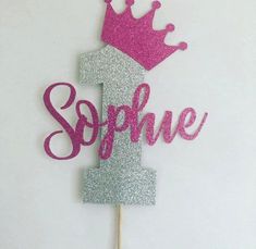 a pink and silver cake topper with a crown on it's head that says, sophhe